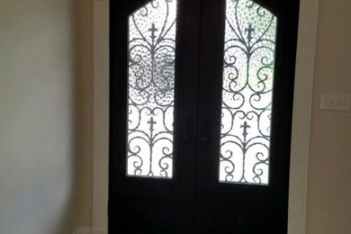 Inspiration for a mid-sized timeless dark wood floor and brown floor entryway remodel in New Orleans with beige walls and a black front door