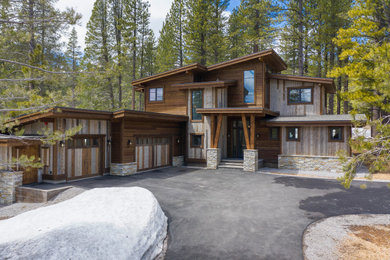 Example of a large mountain style brown two-story wood house exterior design in Other with a shed roof and a shingle roof