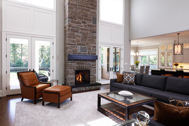 This is an example of a transitional open concept family room in Toronto with white walls, dark hardwood floors, a two-sided fireplace and a stone fireplace surround.