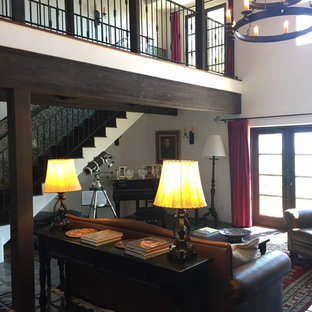 Foto de salón con rincón musical abierto, mediterráneo, de tamaño medio, sin televisor, con paredes blancas, suelo de baldosas de terracota, chimenea tradicional, marco de chimenea de yeso y suelo negro