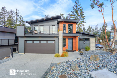 Design ideas for a mid-sized modern grey house exterior in Vancouver with a shingle roof.