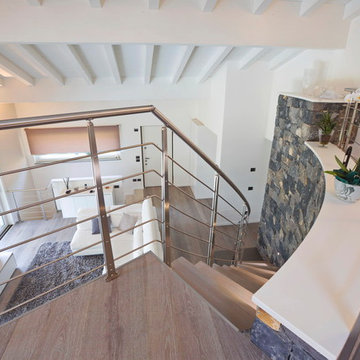 Scala sospesa con gradini in rovere e ringhiera in inox