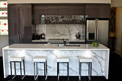 Mid-sized contemporary galley eat-in kitchen in Melbourne with a drop-in sink, recessed-panel cabinets, brown cabinets, quartzite benchtops, multi-coloured splashback, stone slab splashback, stainless steel appliances, dark hardwood floors and with island.