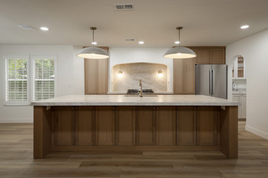 Mid-sized transitional vinyl floor and beige floor eat-in kitchen photo in Other with shaker cabinets, light wood cabinets, quartzite countertops, beige backsplash, stone slab backsplash, stainless steel appliances, an island and beige countertops