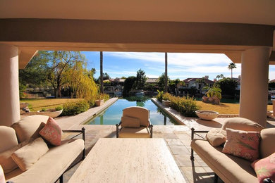 Inspiration for a mid-sized contemporary courtyard patio in Phoenix with natural stone pavers and a roof extension.