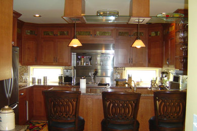 Mittelgroße Rustikale Wohnküche mit Schrankfronten mit vertiefter Füllung, hellbraunen Holzschränken, Küchengeräten aus Edelstahl und Halbinsel in Sonstige