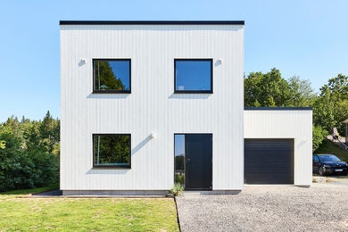 Bild på ett funkis vitt hus, med två våningar