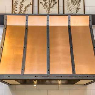 Exemple d'une grande arrière-cuisine industrielle en L avec un évier encastré, un placard à porte plane, des portes de placard noires, un plan de travail en quartz modifié, une crédence blanche, une crédence en carreau de porcelaine, un électroménager en acier inoxydable, un sol en carreaux de ciment, un îlot central, un sol gris et un plan de travail blanc.