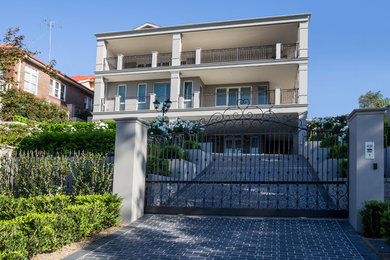 Large traditional three-storey concrete grey house exterior in Sydney with a hip roof.