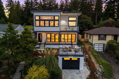 Inspiration for a mid-sized contemporary three-story concrete fiberboard and clapboard house exterior remodel in Seattle with a shed roof and a metal roof