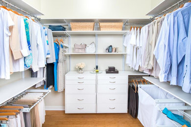 Design ideas for a large modern gender-neutral walk-in wardrobe in Detroit with flat-panel cabinets and white cabinets.