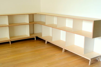 Réalisation d'un grand salon design avec une bibliothèque ou un coin lecture, un mur blanc et parquet clair.