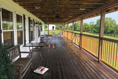 This is an example of a huge farmhouse porch design in Louisville with decking and a roof extension.