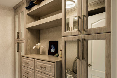 Inspiration for a mid-sized transitional gender-neutral walk-in closet remodel with raised-panel cabinets and medium tone wood cabinets