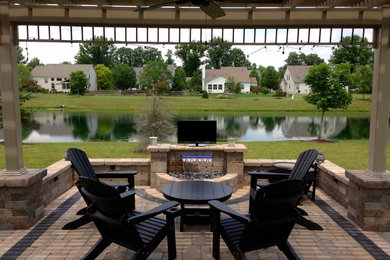 Example of a large arts and crafts backyard brick patio fountain design in Cleveland with a gazebo