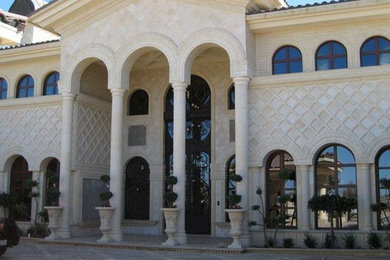 Huge mediterranean beige two-story stone exterior home idea in Los Angeles