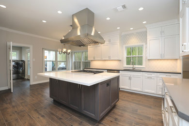 Large transitional u-shaped porcelain tile eat-in kitchen photo in Houston with shaker cabinets, white cabinets, solid surface countertops, stone tile backsplash, stainless steel appliances, an island and gray countertops