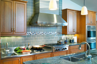 Inspiration for a transitional kitchen remodel in Albuquerque with an undermount sink, raised-panel cabinets, medium tone wood cabinets, soapstone countertops, blue backsplash, ceramic backsplash and stainless steel appliances