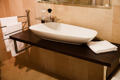 Klassisches Badezimmer mit beigen Fliesen, Keramikfliesen, Keramikboden, Aufsatzwaschbecken und beigem Boden in Sonstige
