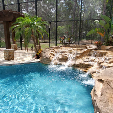 Resort Inspired Pool with Grotto and Sunken Firepit Lounge