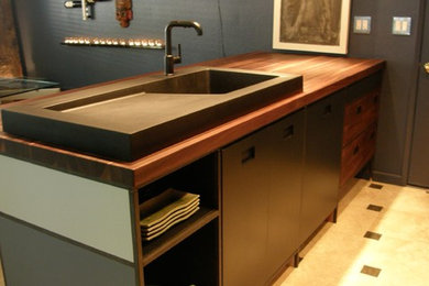 Example of an urban travertine floor kitchen design in Orange County with a single-bowl sink and wood countertops
