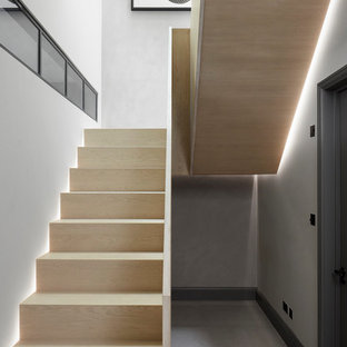 Inspiration for a medium sized contemporary wood u-shaped wood railing staircase in London with wood risers.