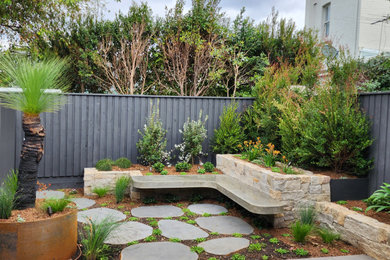 This is an example of a small and australian native contemporary courtyard xeriscape in Sydney with with raised garden bed and natural stone pavers.