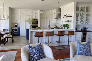 This is an example of a mid-sized contemporary u-shaped kitchen in Los Angeles with a single-bowl sink, shaker cabinets, blue cabinets, marble benchtops, white splashback, ceramic splashback, panelled appliances, porcelain floors, grey floor, white benchtop and recessed.
