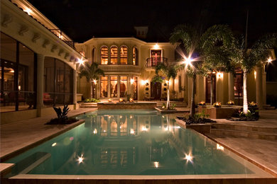 This is an example of a mid-sized mediterranean backyard custom-shaped lap pool in Miami with a hot tub and tile.