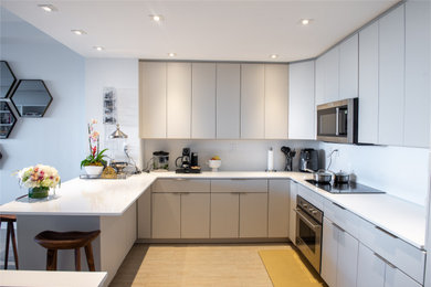 Eat-in kitchen - mid-sized modern u-shaped eat-in kitchen idea in Miami with white cabinets, white backsplash and white countertops