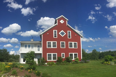 Large country red three-story wood exterior home photo in Burlington with a shingle roof
