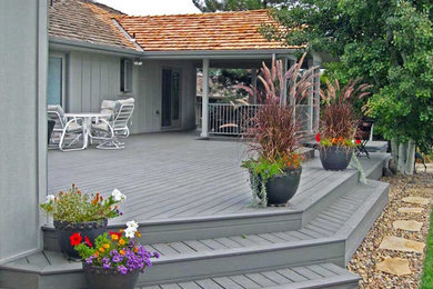 Example of a mid-sized classic backyard deck design in Denver with no cover