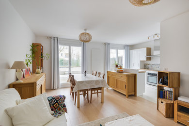 Exemple d'une salle à manger ouverte sur la cuisine tendance de taille moyenne avec un mur blanc, parquet clair et aucune cheminée.