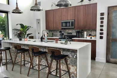 Trendy concrete floor and vaulted ceiling kitchen photo in Miami with a single-bowl sink, flat-panel cabinets, brown cabinets, quartz countertops, multicolored backsplash, cement tile backsplash, stainless steel appliances and white countertops
