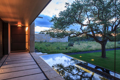 Inspiration for a mid-sized modern concrete floor entryway remodel in Austin with beige walls and a metal front door