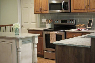 Inspiration for a mid-sized timeless u-shaped vinyl floor and beige floor eat-in kitchen remodel in Other with an undermount sink, raised-panel cabinets, light wood cabinets, granite countertops, gray backsplash, glass tile backsplash, stainless steel appliances and an island