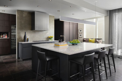 Inspiration for a contemporary galley eat-in kitchen remodel in Calgary with an undermount sink, flat-panel cabinets, gray cabinets, beige backsplash, stainless steel appliances and an island