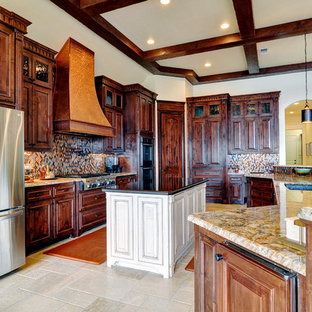 Photo of a large transitional u-shaped kitchen pantry in Dallas with an undermount sink, raised-panel cabinets, medium wood cabinets, granite benchtops, metallic splashback, glass sheet splashback, stainless steel appliances, travertine floors and with island.