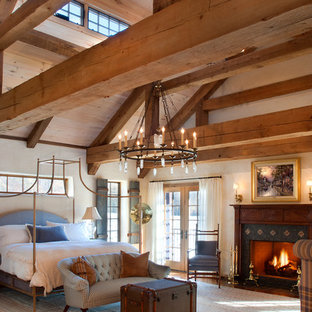 Aménagement d'une grande chambre campagne avec un mur beige, une cheminée standard et un manteau de cheminée en bois.