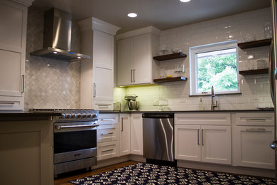 Inspiration for a mid-sized transitional u-shaped medium tone wood floor and brown floor kitchen remodel in Oklahoma City with an undermount sink, shaker cabinets, white cabinets, quartz countertops, white backsplash, subway tile backsplash, stainless steel appliances and a peninsula