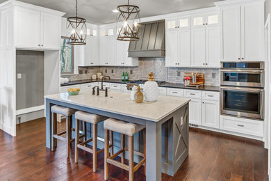 Large transitional u-shaped dark wood floor and brown floor eat-in kitchen photo in St Louis with an undermount sink, shaker cabinets, white cabinets, quartzite countertops, white backsplash, marble backsplash, stainless steel appliances, an island and white countertops