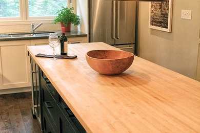 Inspiration for a large cottage u-shaped dark wood floor and brown floor enclosed kitchen remodel in Toronto with a double-bowl sink, recessed-panel cabinets, black cabinets, wood countertops, white backsplash, ceramic backsplash, stainless steel appliances and an island