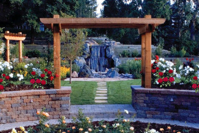 Design ideas for a large transitional backyard full sun formal garden for summer in Denver with with pond and natural stone pavers.