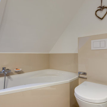 Bad in einer Dachschräge mit Eckbadewanne und Dusche