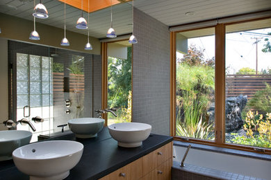 1960s master gray tile alcove bathtub photo in San Francisco with a vessel sink, flat-panel cabinets and light wood cabinets