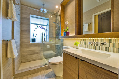 Inspiration for a small contemporary 3/4 bathroom in Hawaii with an open shower, an undermount sink, flat-panel cabinets, engineered quartz benchtops, a one-piece toilet, blue tile, mosaic tile, limestone floors, beige walls, beige floor, a sliding shower screen and medium wood cabinets.