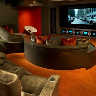 Photo of a medium sized contemporary open plan home cinema in Orlando with red walls, carpet, a projector screen and orange floors.