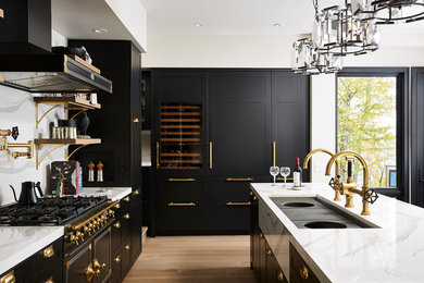 Large transitional light wood floor and yellow floor open concept kitchen photo in Minneapolis with an undermount sink, shaker cabinets, black cabinets, quartz countertops, white backsplash, stone slab backsplash, paneled appliances, an island and white countertops