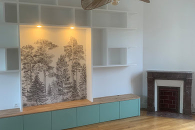 Cette photo montre un grand salon blanc et bois tendance avec une bibliothèque ou un coin lecture, un mur blanc, une cheminée standard, un sol marron et du papier peint.