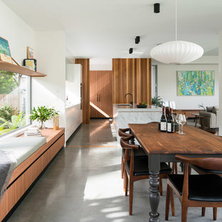 ブリスベンのミッドセンチュリースタイルのLDKの画像 (白い壁、コンクリートの床、グレーの床)